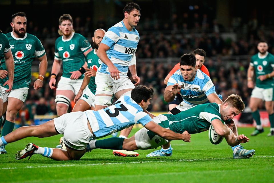 Jack Crowley dives over to score his side's first try despite the efforts of Lucio Cinti of Argentina