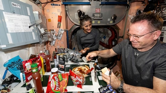 NASA astronauts Suni Williams and Butch Wilmore, both Expedition 71 Flight Engineers, make pizza aboard the International Space Station's galley located inside the Unity module on Sept. 9, 2024. Items are attached to the galley using tape and velcro to keep them from flying away in the microgravity environment. (AP)