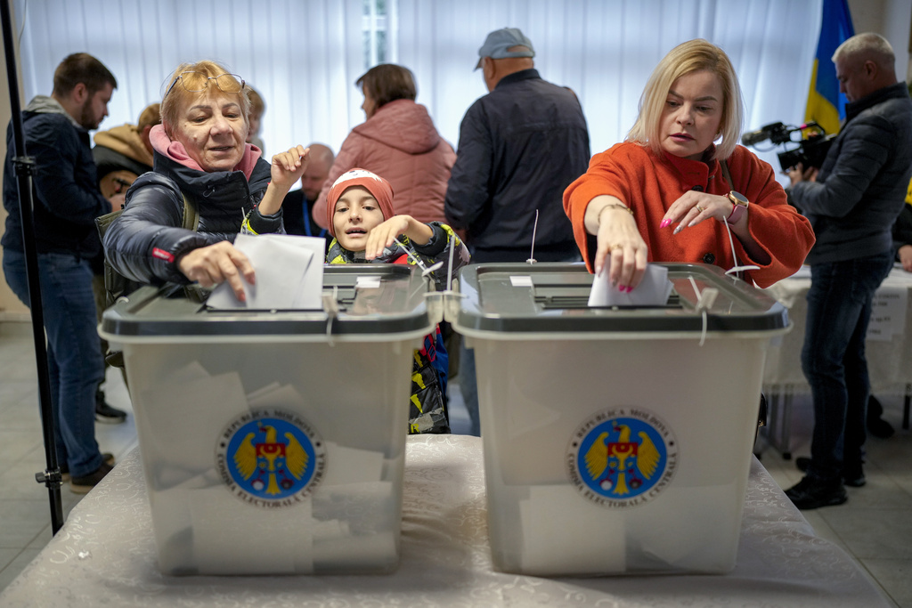 Women cast their vote in Chisinau, Moldova, Sunday, Oct. 20, 2024, during a presidential election and a referendum on whether to enshrine in the Constitution the country's path to European Union membership. (AP Photo/Vadim Ghirda)