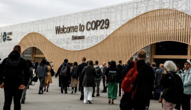 Participants walk by an entrance of COP29, UN Climate Change Conference venue, an event held by UNFCCC in Baku Olympic Stadium.