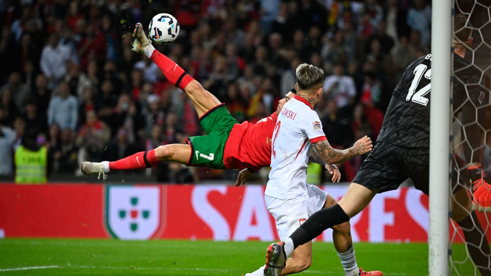 Cristiano Ronaldo (L) attempts a bicycle kick to score Portugal's fifth goal during the UEFA Nations League match against Poland at the Dragao stadium in Porto.