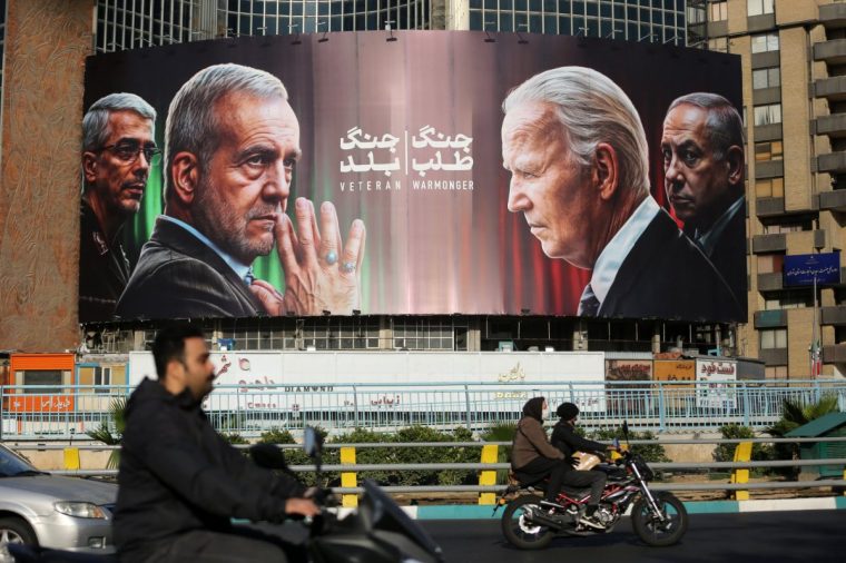 TEHRAN, IRAN - OCTOBER 28: The huge banner with photos of Iranian President Massoud Pezeshkian, Iranian Chief of Staff Major General Mohammad Baqeri, U.S. President Joe Biden, and Israeli Prime Minister Benjamin Netanyahu hung in Veliasr Square in the Iranian capital on October 28, 2024, following the Israeli missile attack on Iran. (Photo by Fatemeh Bahrami/Anadolu via Getty Images)