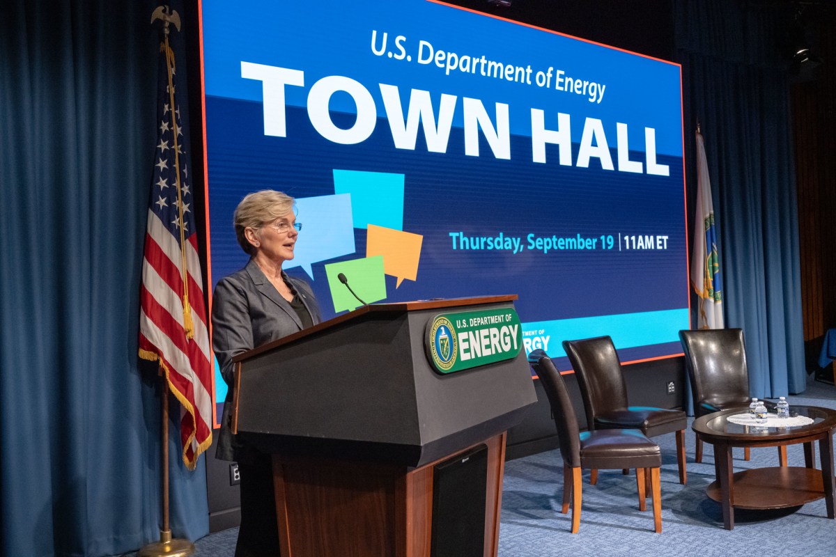 Jennifer Granholm stands at a podium in front of a screen that says Town Hall.