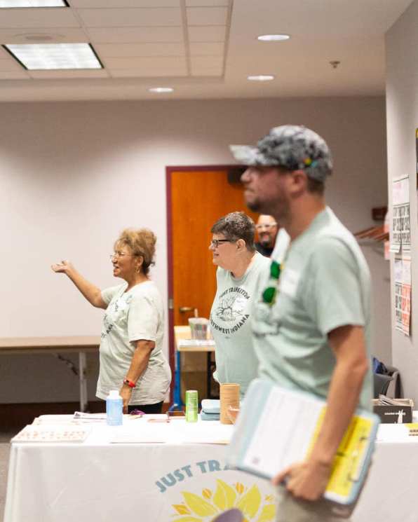 People stand in the back of a meeting room.