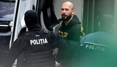 a photo of British-US former professional kickboxer and controversial influencer Andrew Tate (C) led by police officers to the Court of Appeal in Bucharest, Romania in early 2024.