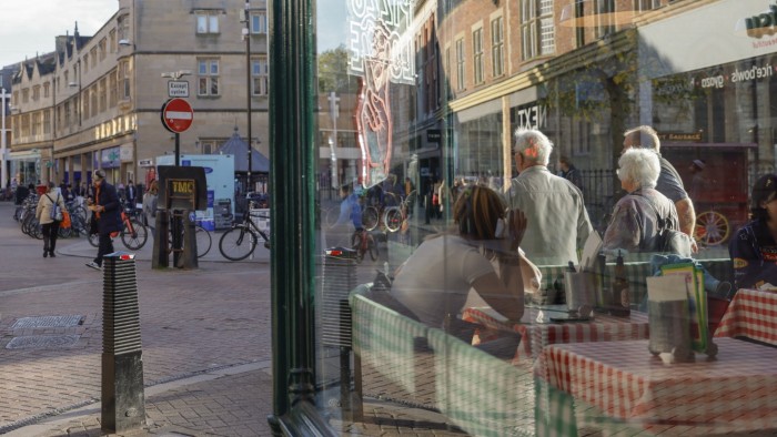 Shoppers pass a cafe in Cambridge, UK