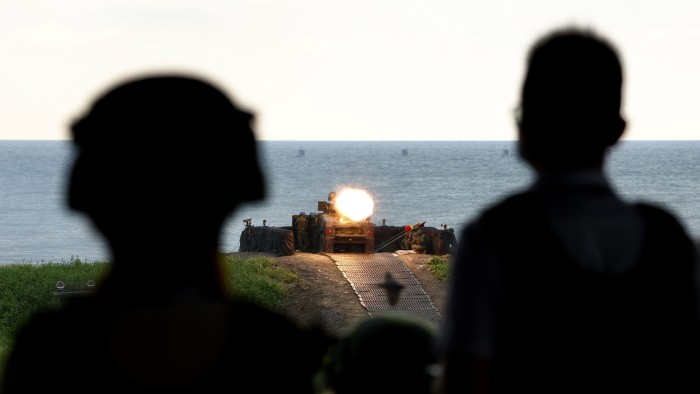 Two Taiwanese soldiers watch a vehicle fire US-made missiles at a target during a shooting exercise in Fangshan last month