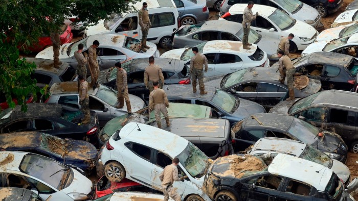 Soldiers search cars damaged by flooding in eastern Spain
