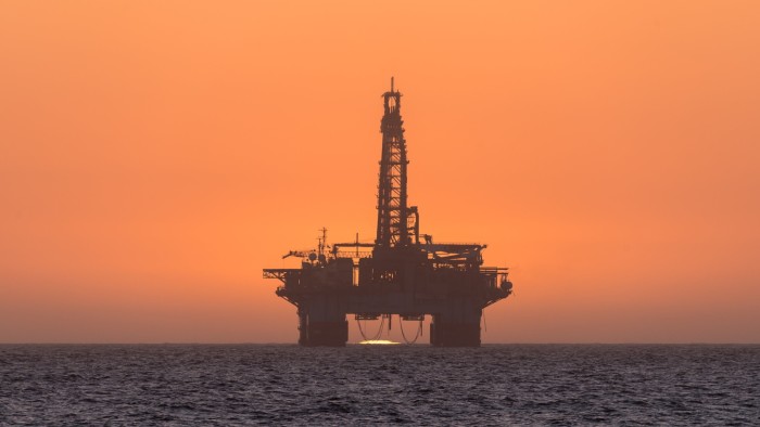The sun sets behind an oil drilling platform at Longbeach, Namibia