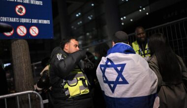 Israelische Fans kommen zum Spiel Frankreich gegen Israel und unterhalten sich mit der Polizei. Ein Fan hat eine Israel-Flagge um den Körper.