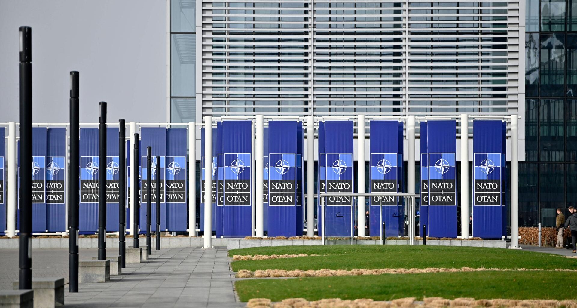 Das NATO-Hauptquartier in Brüssel von aussen, mit NATO-Logos vor der Tür.
