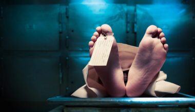 a body on a morgue table with only the feet showing and a toe tag on the big toe