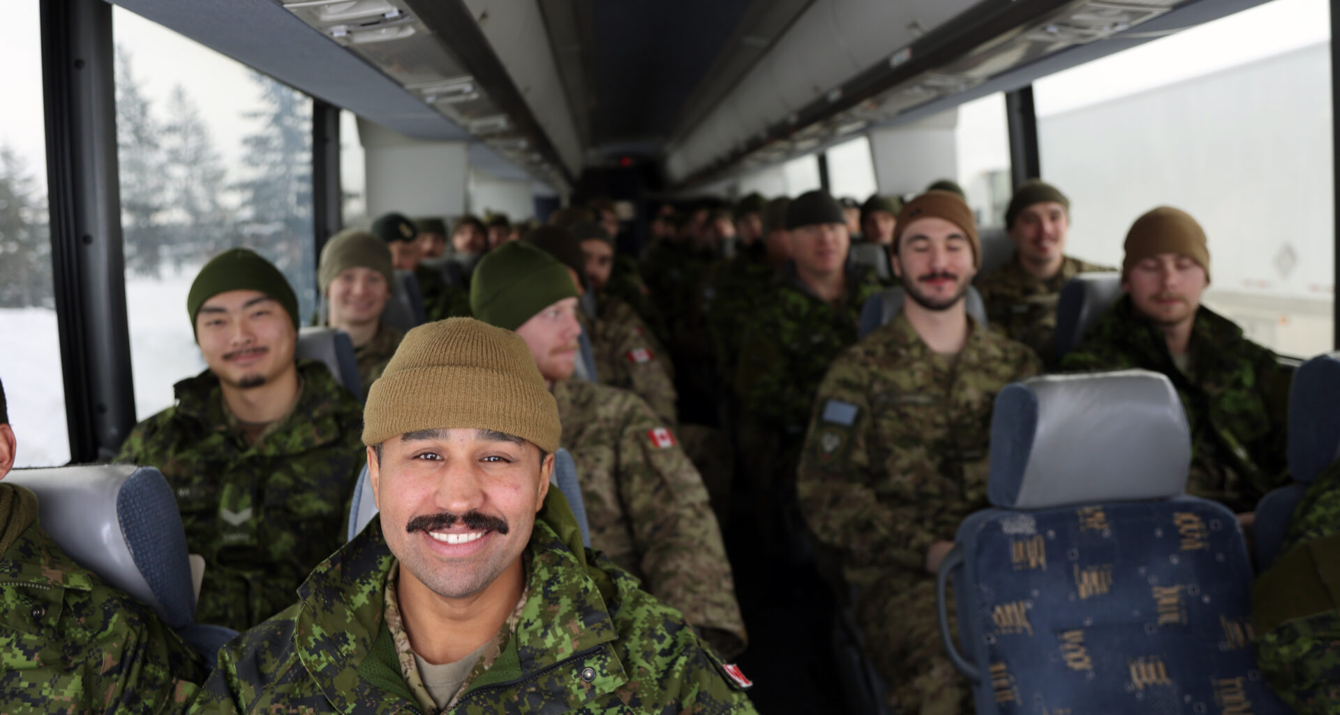 Cpl. Aaron MacLennan sits at the front of the bus leaving CFB Shilo on Friday. About 175 soldiers deployed from the base near Brandon, travelling to Winnipeg by bus, from where they will fly to Latvia as part of Operation Reassurance. The operation trains NATO allies and deters aggression in the area through military presence. Soldiers from Shilo will be serving a six-month deployment as part of the operation. (Connor McDowell/The Brandon Sun)