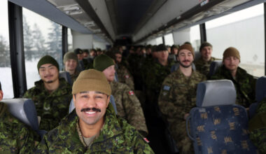 Cpl. Aaron MacLennan sits at the front of the bus leaving CFB Shilo on Friday. About 175 soldiers deployed from the base near Brandon, travelling to Winnipeg by bus, from where they will fly to Latvia as part of Operation Reassurance. The operation trains NATO allies and deters aggression in the area through military presence. Soldiers from Shilo will be serving a six-month deployment as part of the operation. (Connor McDowell/The Brandon Sun)