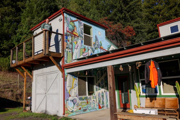 Solar Punk Farms cofounder Spencer Scott stands on the balcony,...
