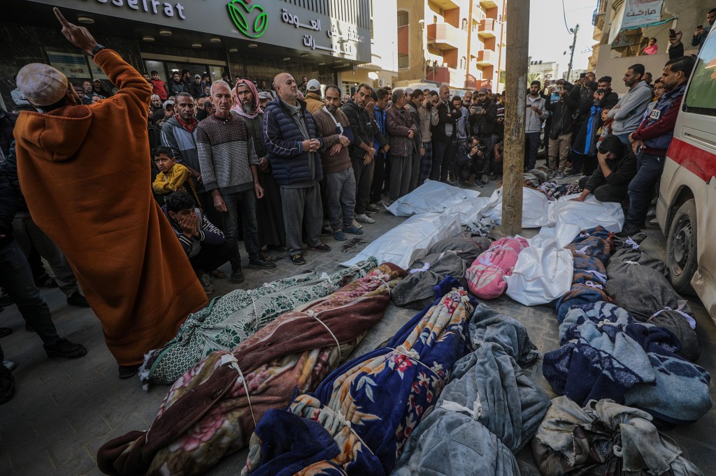 Palestinians praying next to the covered bodies during a funeral in Al Nuseirat refugee camp, after a fatal Israeli airstrike on December 13, 2024