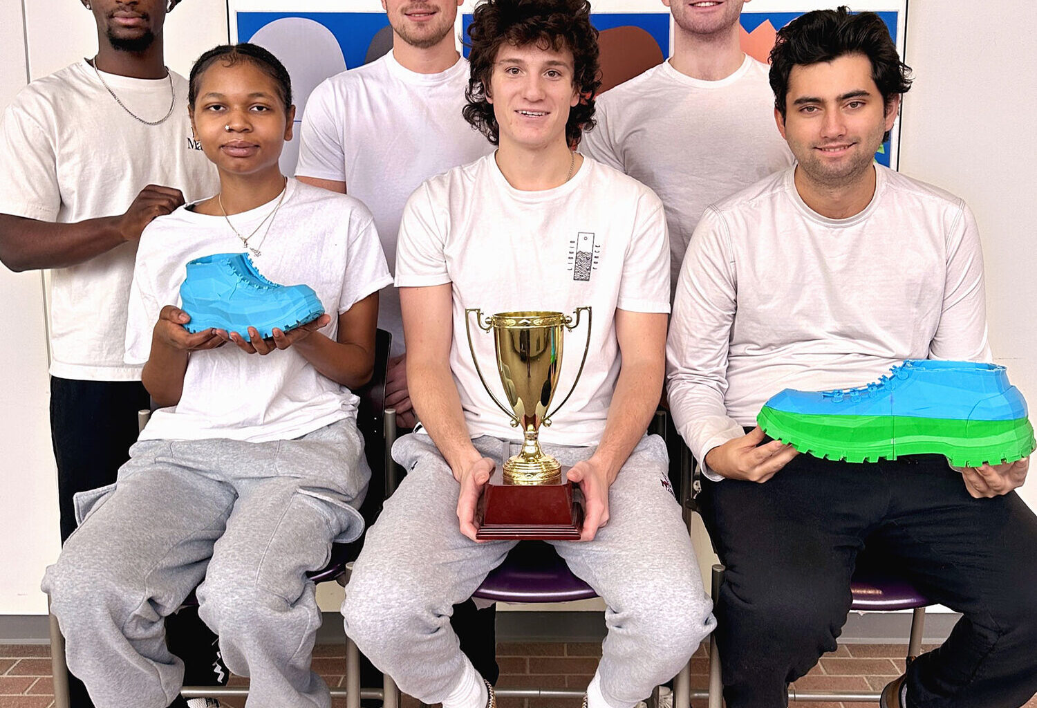 The members of the winning team (nicknamed the "Hopeful Flying Penguins") for the SUNY Potsdam Business Plan Competition posed for a photo along with their trophy and product prototype after class. The student group included (clockwise, from top left): Junior Oduro, Drew Rose, David Scovil, Teddy Morey, Ben Lagoner and Tawaiian Holmes.: