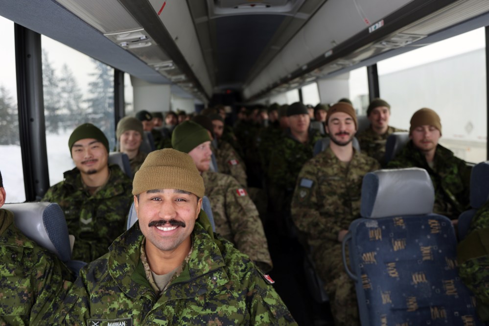 Cpl. Aaron MacLennan sits at the front of the bus leaving CFB Shilo on Friday. About 175 soldiers deployed from the base near Brandon, travelling to Winnipeg by bus, from where they will fly to Latvia as part of Operation Reassurance. The operation trains NATO allies and deters aggression in the area through military presence. Soldiers from Shilo will be serving a six-month deployment as part of the operation. (Connor McDowell/The Brandon Sun)