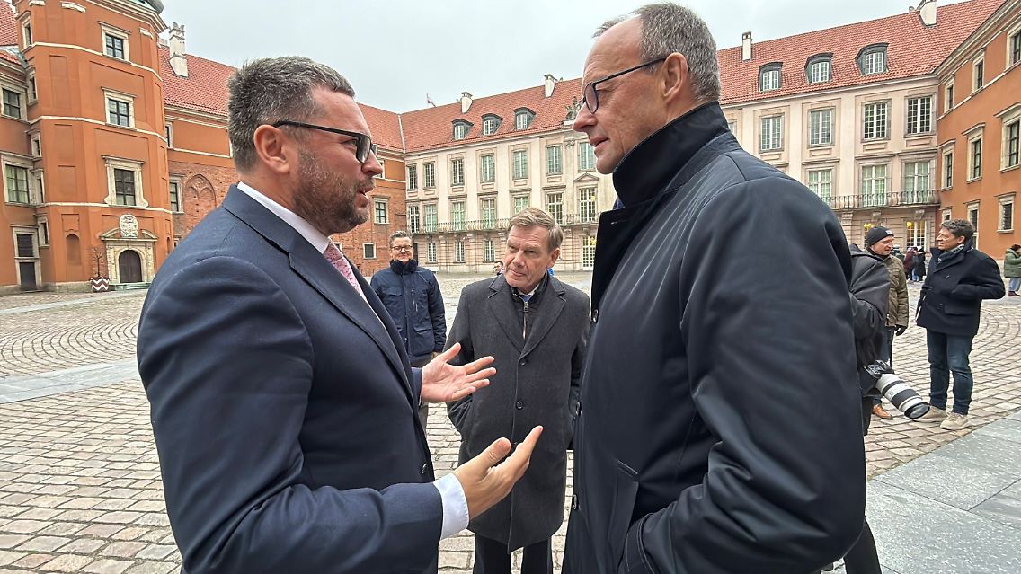 Merz spricht mit einem Mitarbeiter des im Warschauer Königsschloss beheimateten Museums.