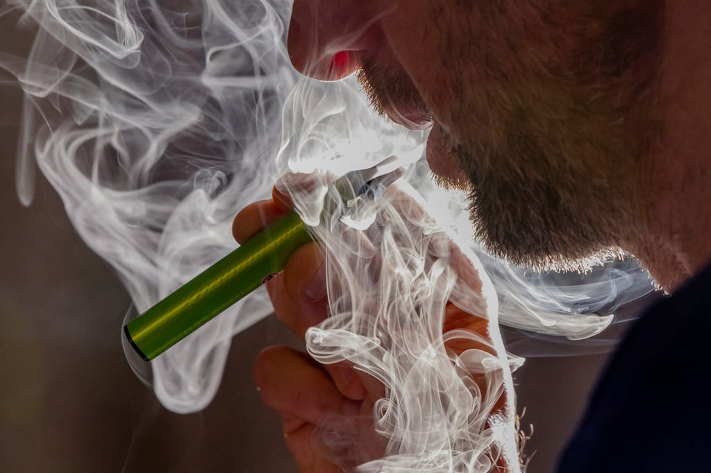 A man vapes on a disposable electronic cigarette in Brussels ahead of Belgium’s ban on the sale of disposable vapes on New Year’s Day. Photo: AP