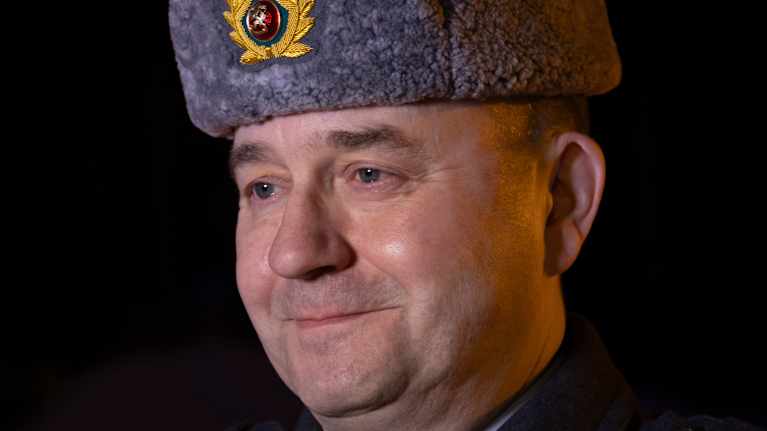 Henkilö seisoo virkapuvussa sotilashenkilöiden perinteisessä asussa.