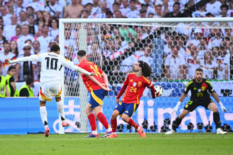 (L-R) Germany's Jamal Musiala in action against Spain's Aymeric Laporte, Marc Cucurella and goalkeeper Unai Simon during the UEFA EURO 2024 quarter-final soccer match between Spain and Germany at the MHP Arena. The men's Euro 2024 quarter-finals between Germany and Spain was the most watched television broadcast in Germany this year, data from public broadcasters ARD showed. Tom Weller/dpa