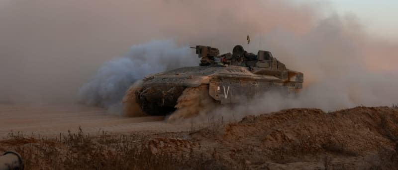An Israeli military armoured vehicle rolls in an area bordering the Gaza Strip on June 9, 2024, amid the ongoing conflict between Israel and the Palestinian Hamas militant group. (Photo by MENAHEM KAHANA/AFP via Getty Images)