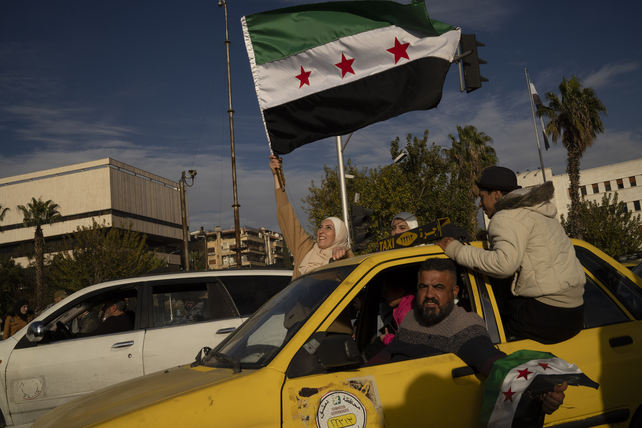 A woman waves an Syrian opposition flag in celebration days after the fall of Bashar al-Assad's government in Damascus, on December 12, 2024.