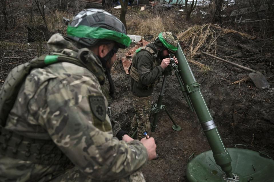 Policemen of Ukraine’s 'Khyzhak' Brigade prepare to fire a mortar towards Russian troops (Reuters)