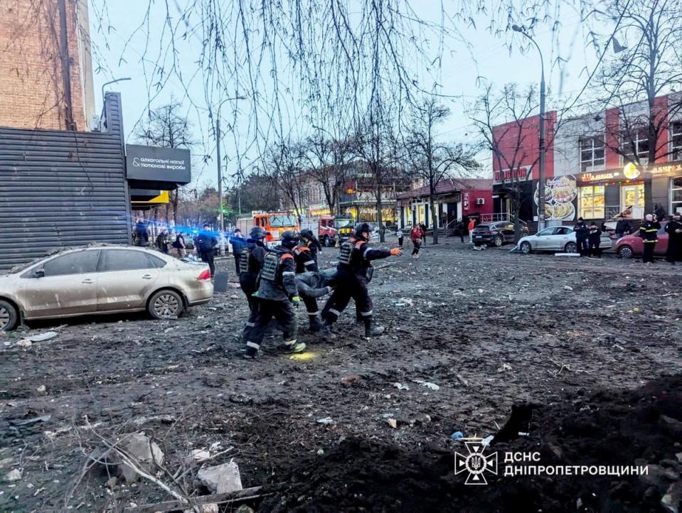 Rescuers evacuate a local resident from a residential building heavily damaged during a Russian missile attack on Christmas Eve (via REUTERS)