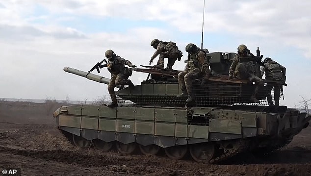 Russian servicemen jump off a T-90M Proryv tank during a combat training for assault units in an undisclosed location