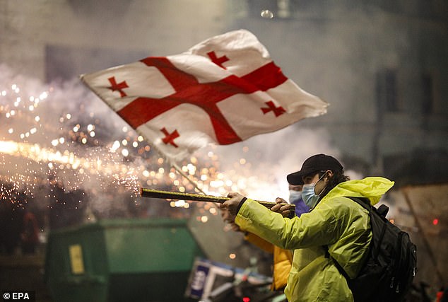 Georgian opposition supporters launch fireworks towards the police during a protest in front of the Parliament building in Tbilisi, Georgia, 30 November 2024
