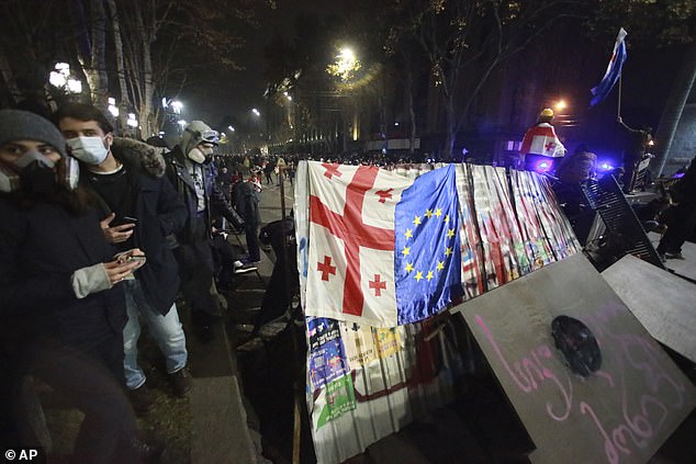 Demonstrators build a barricade during a rally outside the parliament's building to protest the government's decision to suspend negotiations on joining the European Union for four years in Tbilisi, Georgia, early Sunday, Dec. 1, 2024