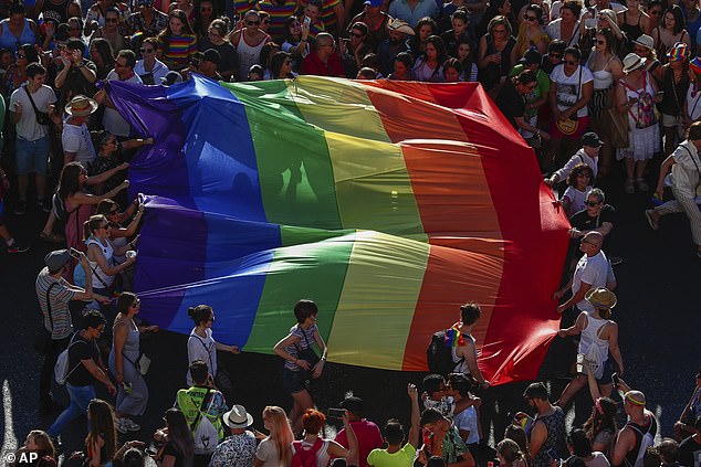 Participants of the annual LGBTQ pride parade carry the rainbow flag in Madrid, Spain