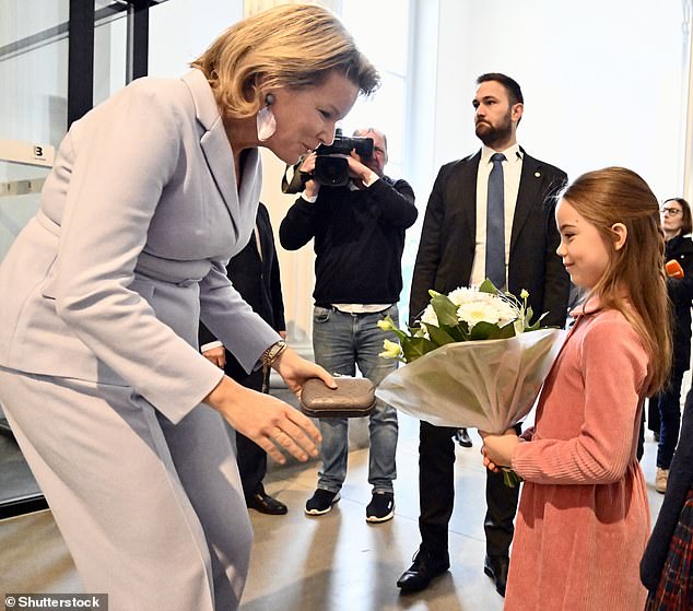 During the visit, the mother-of-four shared a sweet moment with a little girl after she presented the queen with a bouquet of white flowers