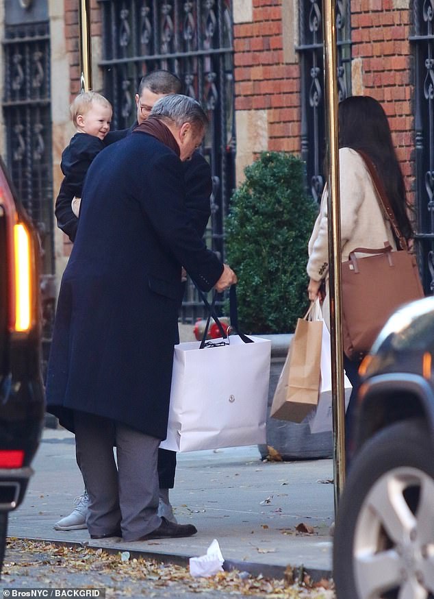 Baby Holland appeared to be in a delightful mood as her grandfather carried what appeared to be a bag full of gifts