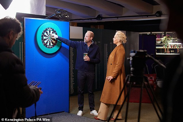 Dressed in plastic-free trainers by the British brand HEVEA and a casual blue jumper, the Prince appeared relaxed as he threw darts with Waddingham, 50, and sipped a pint of cider at the bar