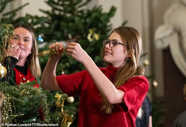 Princess Estelle pictured deciding where to play her Christmas tree ornament