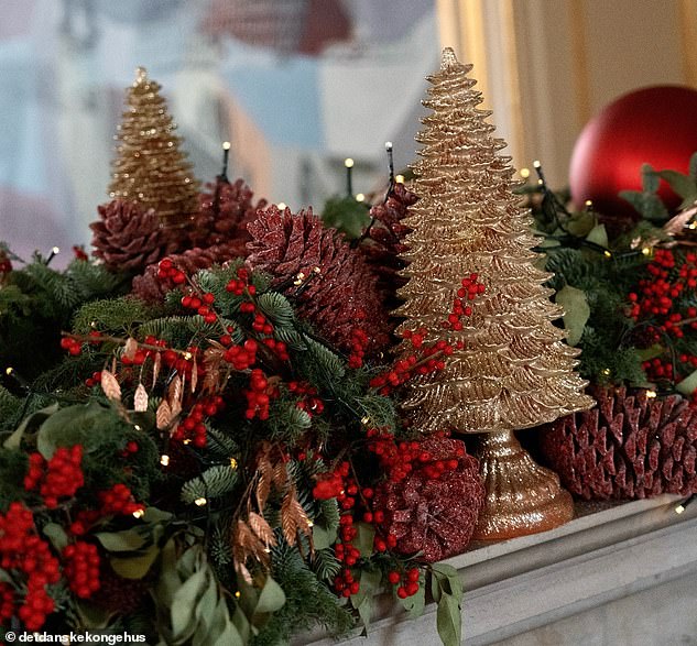 A mantelpiece in the royal residence is decorated with a garland laced with red berries