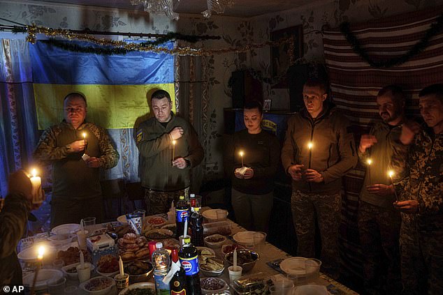 Ukrainian servicemen of 117th Separate Heavy Mechanized Brigade pray before a Christmas dinner in Pokrovsk direction on December 24
