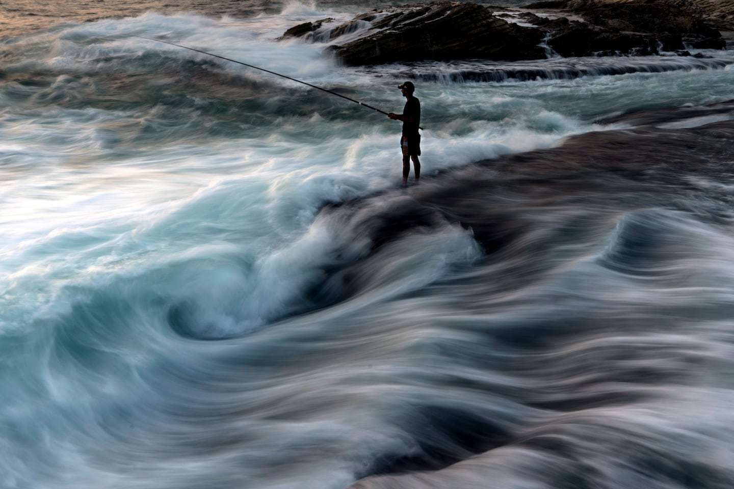 A fisherman cast his line into the Mediterranean from a rocky area along the coastline in Beirut on July 27.
