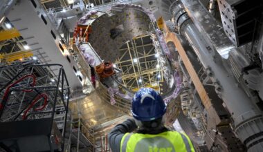 A man takes a picture of a module being assembled at the international nuclear fusion project