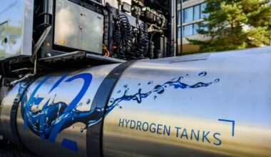 A hydrogen tank sits attached to an idle semi truck.