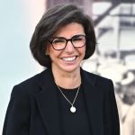 A woman in black smiles.