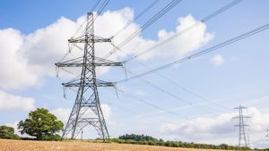 National grid energy network. Electricity pylons in UK countryside, rural landscape