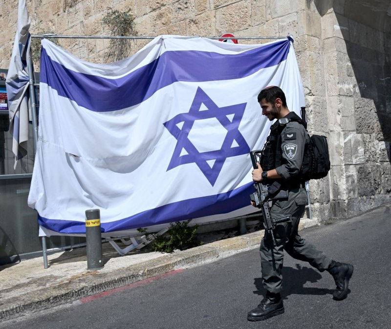 An Israeli border police patrols past a national flag at the Dung Gate of the Old City of Jerusalem, which leads to the southern wall of the Temple Mount and the Western Wall in Jerusalem in August. File Photo by Debbie Hill/ UPI