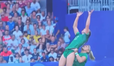 Woman on the Ireland Rugby team picking up one of her teammates to catch the ball