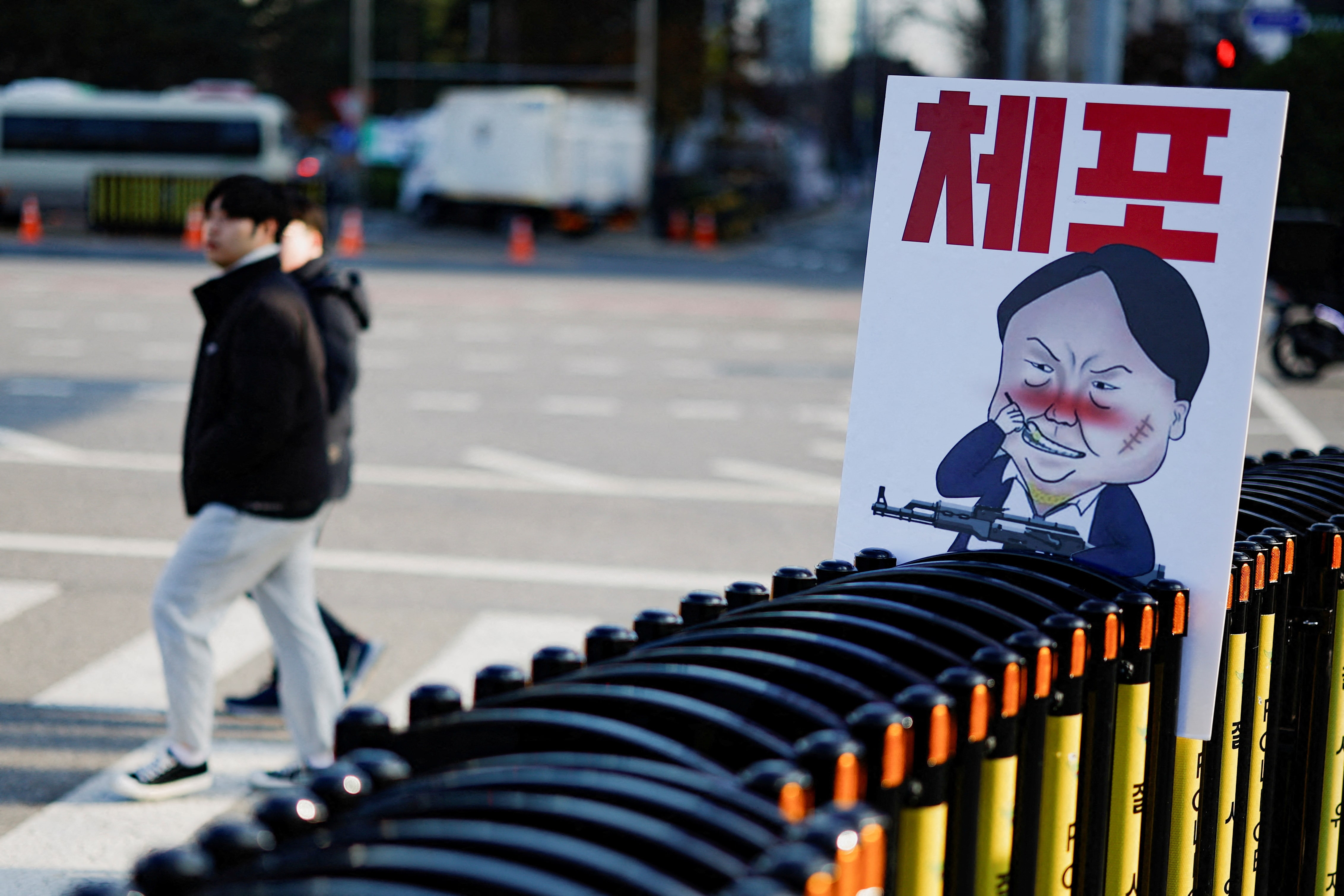 A pedestrian walks past a banner denouncing South Korean President Yoon Suk Yeol, in Seoul