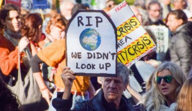 2KEFP4Y London, England, UK. 12th Nov, 2022. A protester outside Shell HQ holds a sign referencing the film