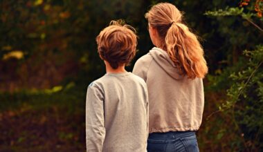 Bildbeschreibung: Ein junge und ein Mädchen das in eine richtung schauen und von hinten fotografiert sind.